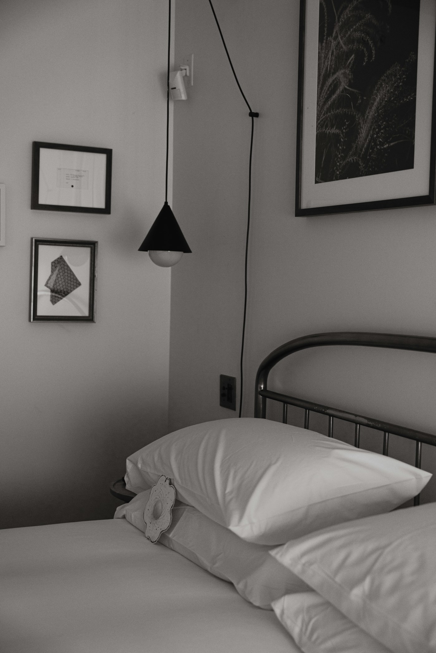 A bedroom with bedside furniture and fabric bedding.