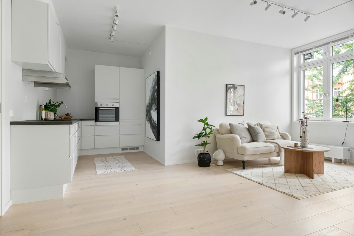 A bright furnished living room showing the window and seating arrangement.